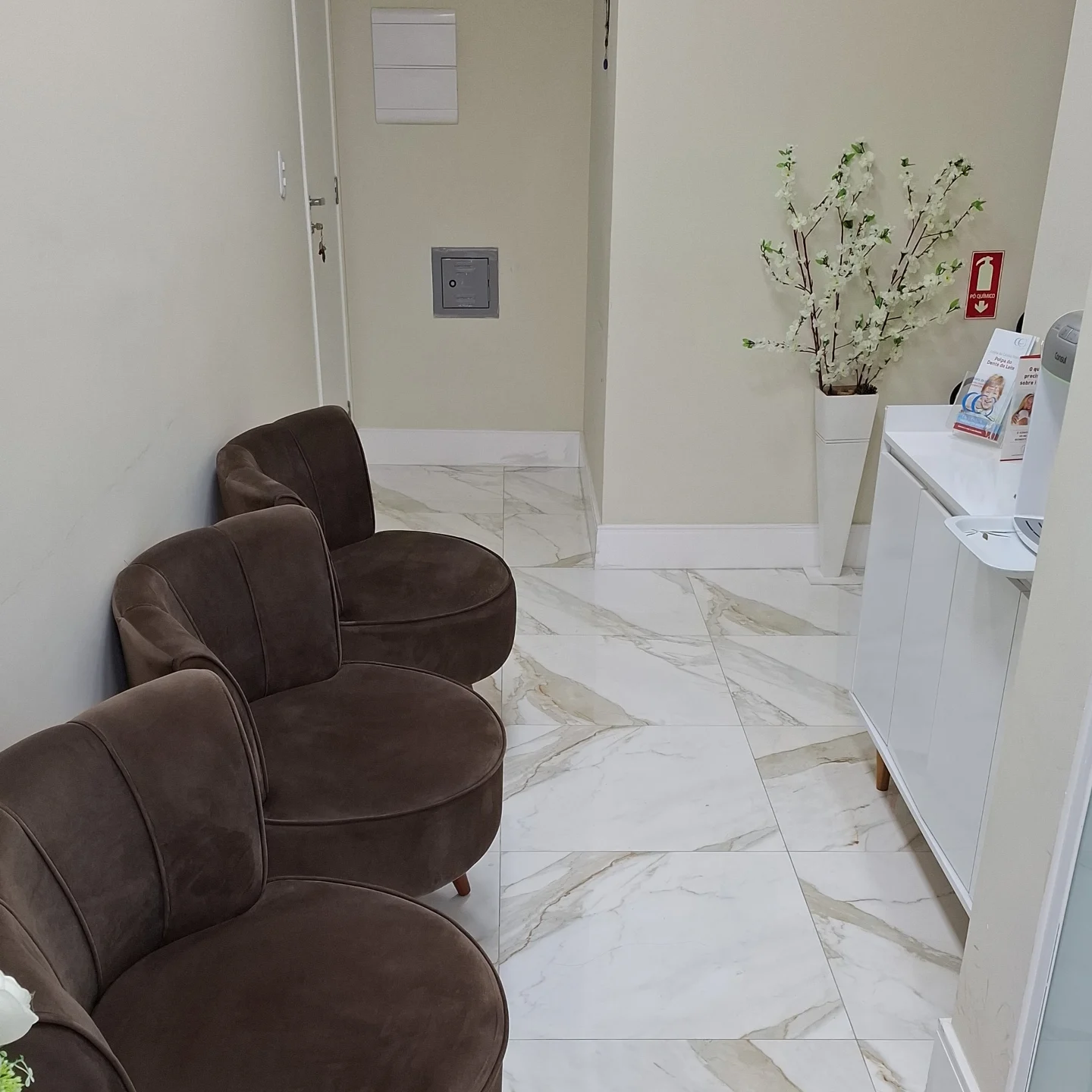 Recepção do Ateliê PeriOdonto, com estação de água e entrada em vidro